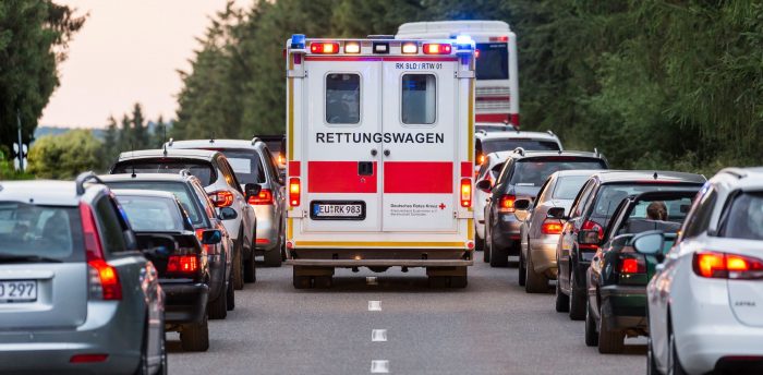 Ein Rettungswagen der durch eine Rettungsgasse fährt